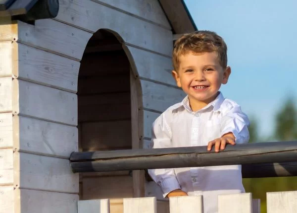 fotografia dziecięca łódź lifestyle chłopiec na drabince stoi na podeście przy domku T3