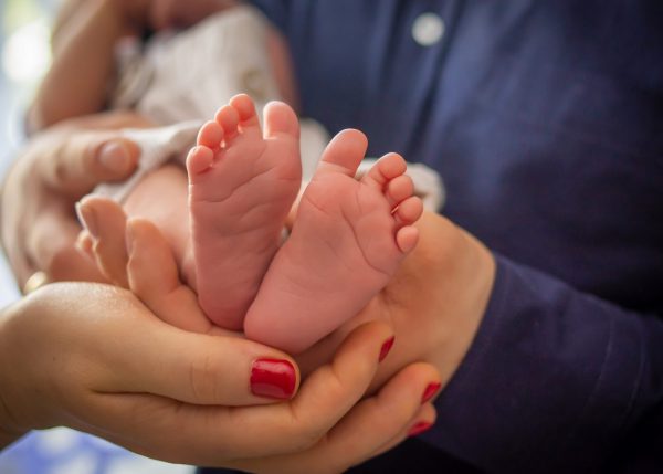 Naturalna sesja noworodkowa Zgierz stopki w dłoniach rodziców