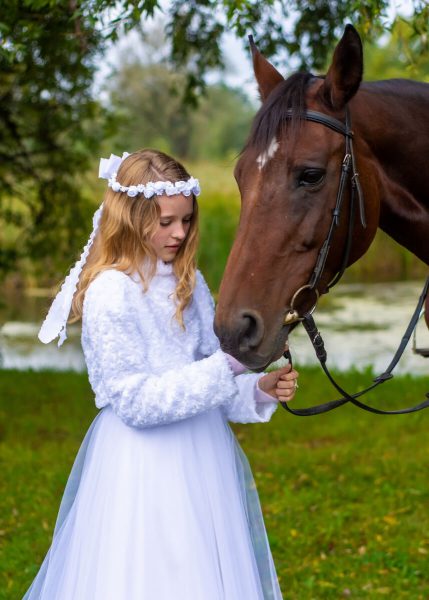 sesja komunijna z koniem łódź dziewczynka stoi obok konia