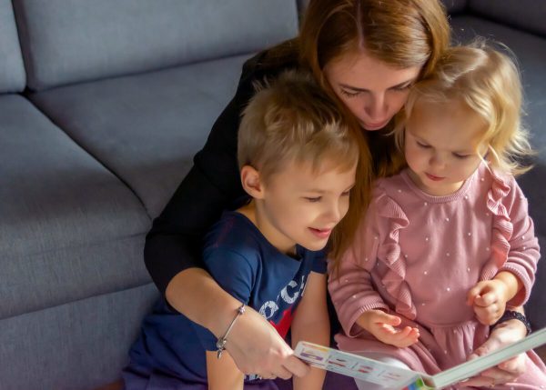 fotografa dziecięca rodzinna łódź mama z dziećmi czyta książkę na podłodze